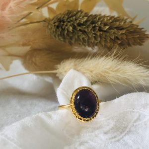 Bague or et pierre d'Améthyste sur un tissu